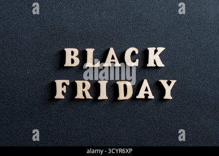 Wooden letters with the inscription black friday on a black background, close up, top view. Time for promotions and sales in stores Stock Photo
