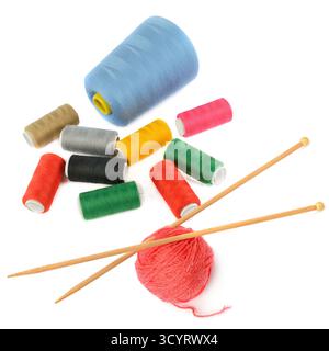 A flat lay of vibrant threads, a ball of red yarn, and wooden knitting needles is perfect for showcasing DIY and craft concepts. The white background Stock Photo