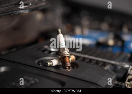 Spark plug replacement. Close up old spark plug, car maintenance concept. Stock Photo