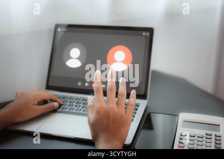 Person having an online video call on laptop for remote meeting and virtual communication, concept of digital connection, online conference, and work Stock Photo