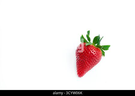 Bright red strawberry with green leaves isolated on white background. Ideal for healthy food, organic branding, and clean minimalist design. Stock Photo