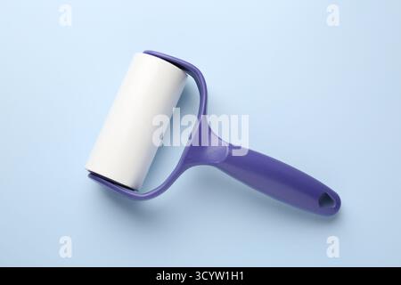 One lint roller on light blue background, top view Stock Photo