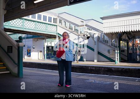 Older woman looking on smartphone at Lewes railway station Stock Photo