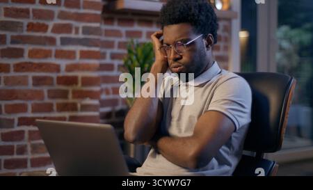 Businessman ethnic African American business man employer online laptop working deadline night overwork evening office manager tired exhausted worker Stock Photo