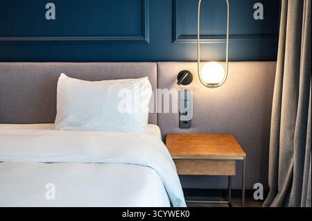 Modern Cozy Bedroom Interior with White Bedding and Soft Lighting Stock Photo