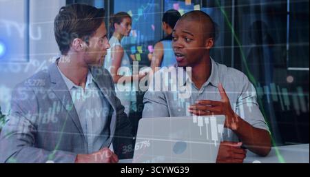 Discussing stock graphs two professionals collaborating in office with laptop and mobile whiteboard Stock Photo