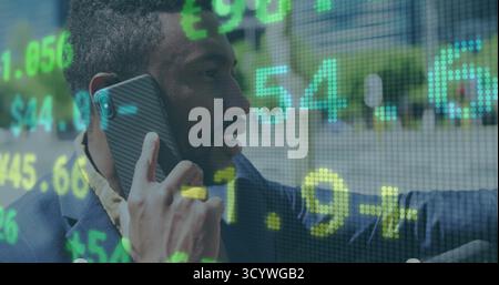 Holding businessman wearing blazer making smartphone call outside office, with stock ticker overlay Stock Photo