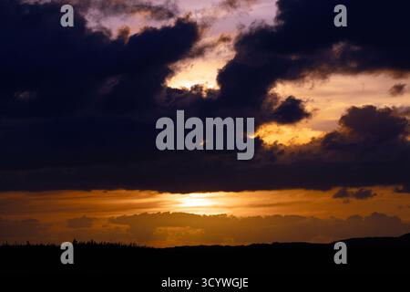 Dramatic Sunset with Dark Clouds Over Newfoundland Landscape Stock Photo