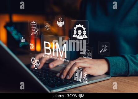 Engineer using laptop with BIM Icons representing Building Information Modeling technology for architecture, data, construction planning, 3D modeling, Stock Photo