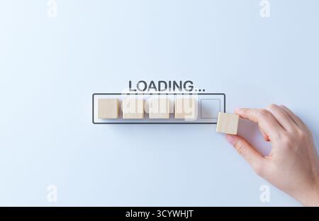 Loading progress concept with wooden blocks forming loading bar, symbolizing business growth, process improvement, patience, update, waiting Stock Photo