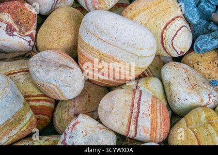 Close-up of striped natural stones displaying rich earthy colors and mineral layers. The image highlights the organic beauty, texture, and geological Stock Photo