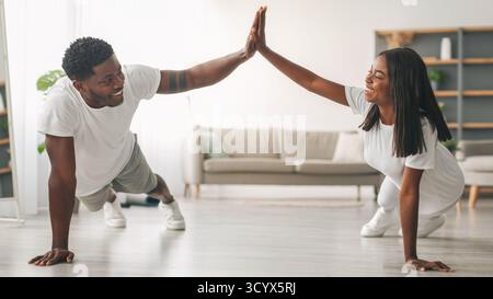 Young black couple planking and giving high five Stock Photo