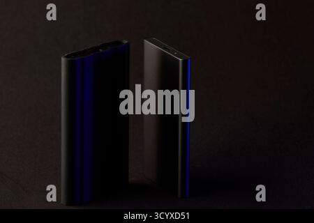 Two sleek SSD drives standing upright on black surface with soft light reflections. Clean technology concept highlighting data security, performance, Stock Photo