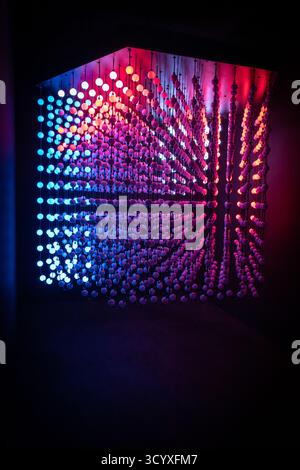 A cube made of glowing, multicolored light bulbs. Stock Photo
