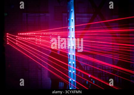 Red laser beams, creating a striking, futuristic atmosphere. Stock Photo