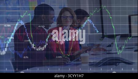 Collaborating three professionals reviewing financial charts at conference table, with tablet Stock Photo