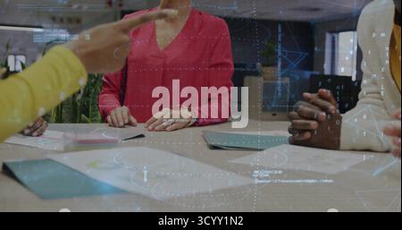 Collaborating group of professionals analyzing printed reports in meeting room, with data overlays Stock Photo