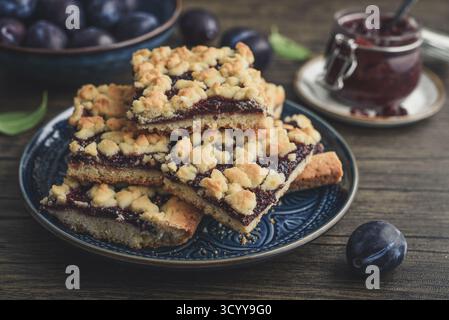 Traditional German Zwetschgenkuchen on blue plate with sliced plums and plum jam, closeup Stock Photo