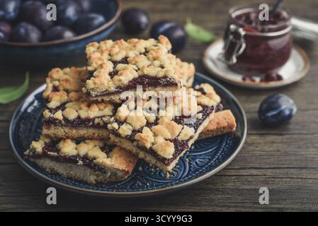 Traditional German Zwetschgenkuchen on blue plate with sliced plums and plum jam, closeup Stock Photo