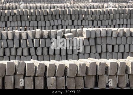 A pile of neatly arranged raw bricks in Brickfield. Raw bricks made of soil are sun-dried before putting into the furnace. Stock Photo