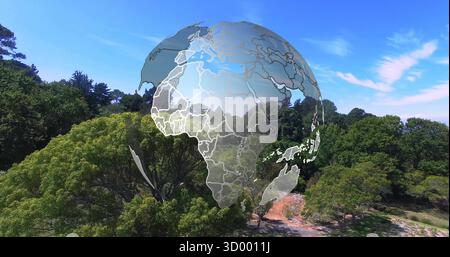 Displaying semi-transparent digital globe floating above wooded park, with winding dirt pathway Stock Photo