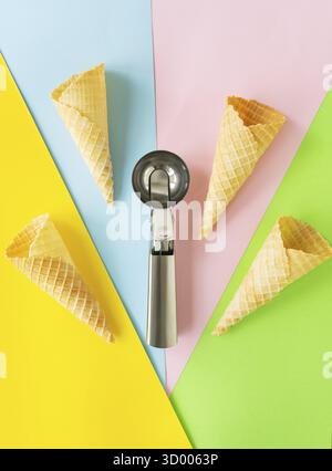 Wafer cups on a multi-colored bright background along with a metal spoon. Takeaway ice cream concept, vertical photo Stock Photo