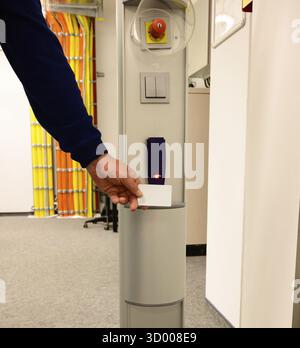 Hold the access card in front of an access system in a data center Hold the access card in front of an access system in a data center Stock Photo