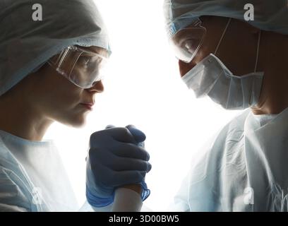 Doctors in gloves make handshake on white background Stock Photo