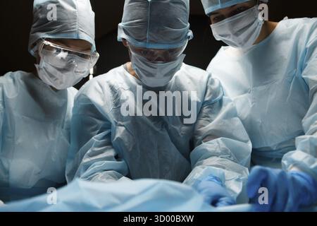 Photo of doctors working in operating room, black background Stock Photo