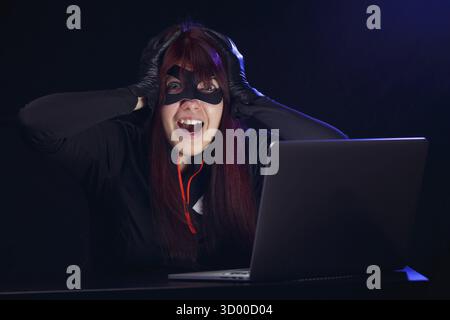Brunette steals information from computer at night Stock Photo