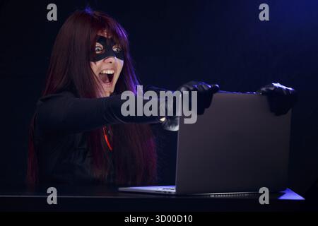 Girl steals information from computer at night Stock Photo