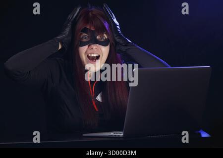 Hacker steals information from computer at night Stock Photo
