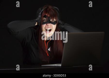 Woman steals information from computer at night Stock Photo