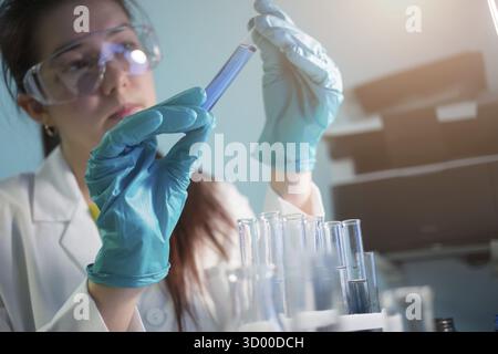 Woman works with laboratory test tubes in rubber gloves Stock Photo