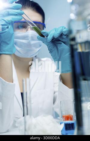 Young scientist with test tubes in laboratory Stock Photo