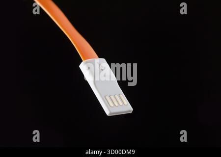Orange cable on isolated black empty background Stock Photo