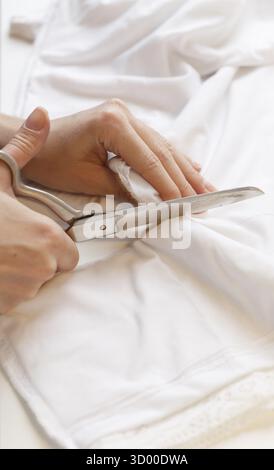 Seamstress tailors with scissors cloth on table close-up Stock Photo