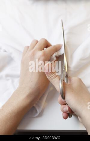 Woman tailors with scissors fabric on table close-up Stock Photo