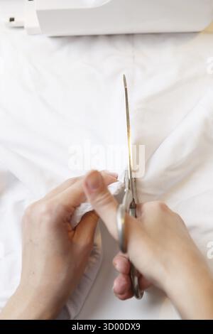 Seamstress tailors with scissors fabric on table close-up Stock Photo