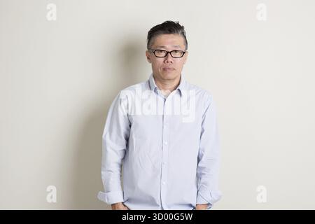 Portrait of single mature 50s Asian man in casual business talking on ...