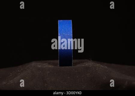 single blue roll of decorators masking tape isolated on a black background Stock Photo