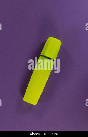 single new yellow high lighter pen isolated on a purple background Stock Photo