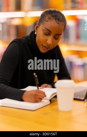 Focused student taking notes in library Stock Photo