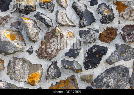 Close-up of Volcanic Rock Wall Texture with Lichen and White Mortar in Santorini, Greece. 6 October 2025 Stock Photo