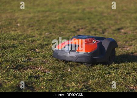 robotic lawn mower on a green grass lawn under sunlight. High quality photo Stock Photo