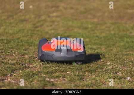 Automated lawn mower robot on green grass, ready to cut and maintain a perfect yard. High quality photo Stock Photo