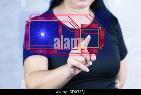 A person's hand touches a circuit board or computer chip displayed in digital or holographic form. Stock Photo