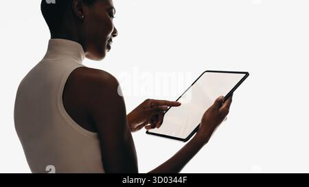 Modern lifestyle concept showing a woman holding and interacting with a tablet device. Stock Photo
