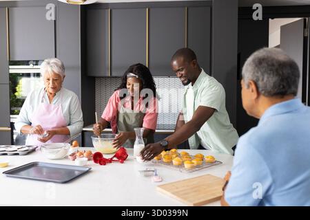 Family baking together in modern kitchen, preparing cupcakes with joy and teamwork. cooking, lifestyle, home, preparation || Model released Stock Photo