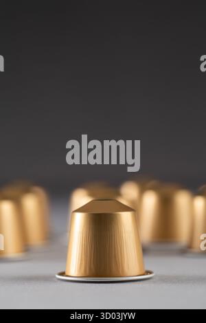 gold coffee capsules arranged on a neutral background, showcasing their sleek and modern design. Ideal for coffee lovers and advertising purposes. Stock Photo